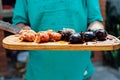 Argentine steakhouse man carrying a table with chorizos Ã¢â¬â¹Ã¢â¬â¹and blood sausages